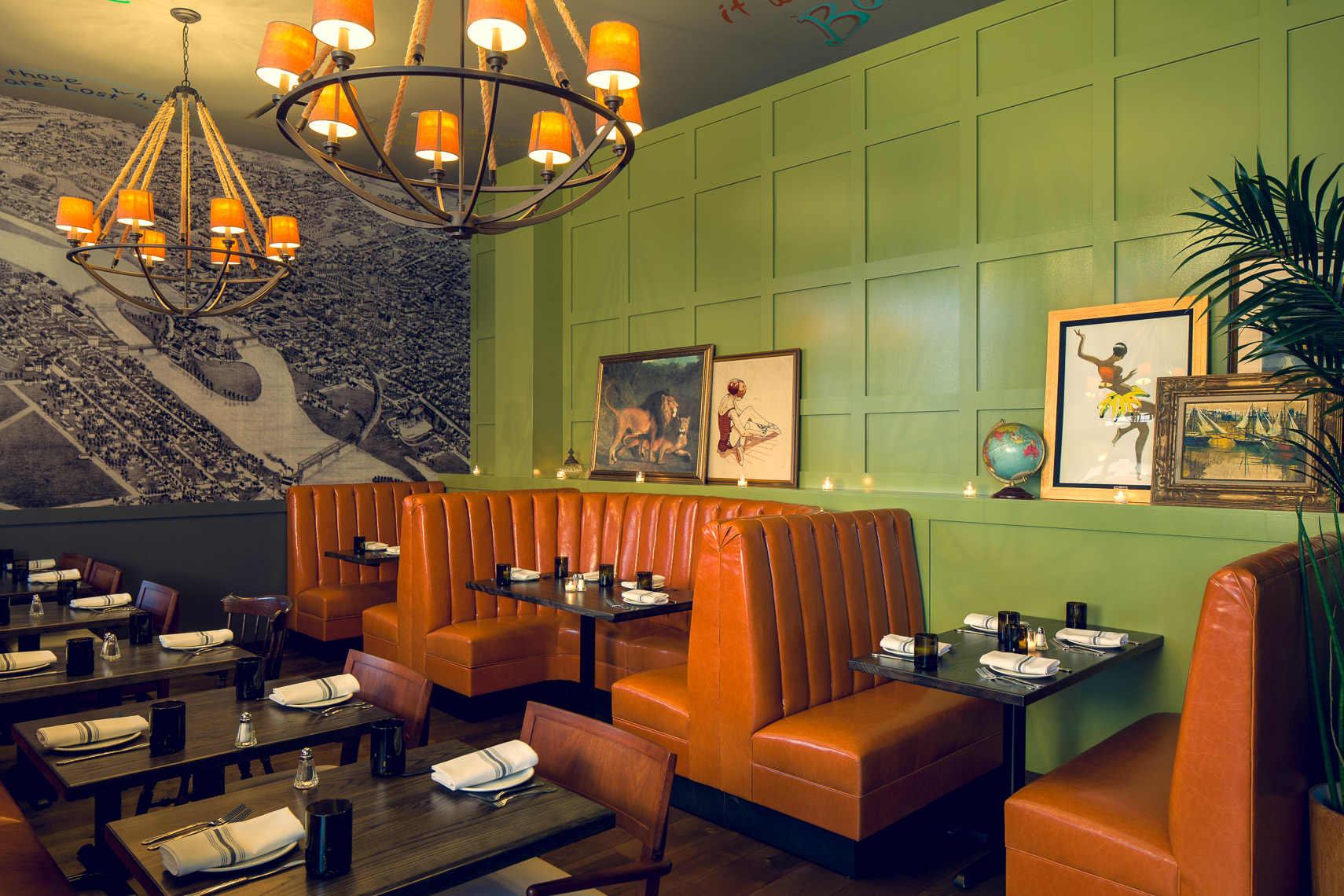 restaurant interior with green walls and orange upholstered booths