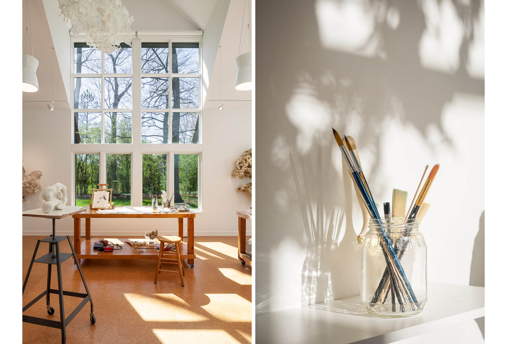 Artist studio with large window, white walls and jar of paint brushes
